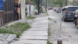 Terlihat pekerjaan tutup uditch tidak rapi dan lebih tinggi dari jalan menghalangi air masuk ke jalur drainase, Selasa (17/1/23).