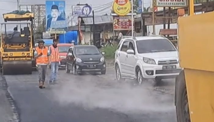 Penghamparan aspal pada pekerjaan Rehabilitasi Minor Jalan Kota Padang dan Kota Bukittinggi mengeluarkan kepulan asap, Sabtu (11/3/23).