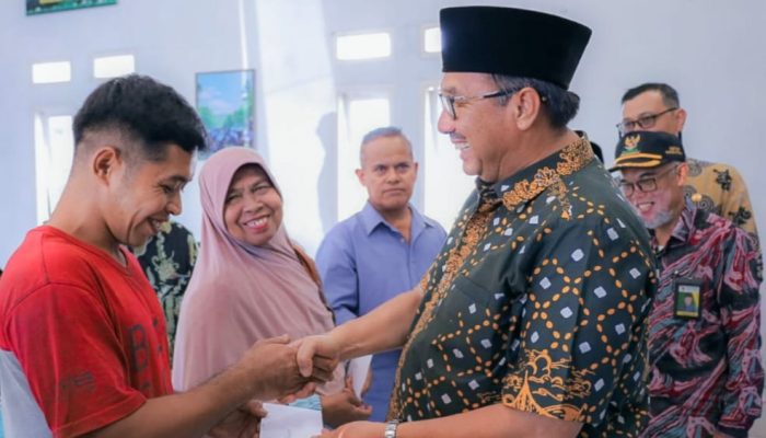 Benny Utama saat menyerahkan bantuan uang kepada para korban terdampak angin punting beliung di Kantor Camat Bonjol Kamis (8/6/23)